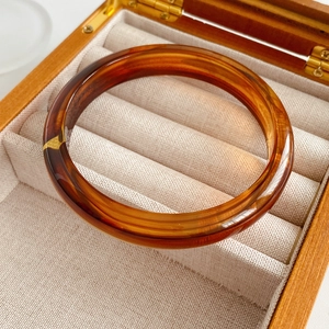 Detail shot of amber resin bangle with tortoiseshell pattern on velvet jewelry box