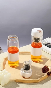 Detail view of 450ml magnetic glass tea cup with insulated white leather sleeve