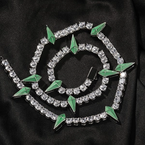 Macro shot of silver tennis chain necklace with sparkling zircons and green spikes