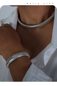 Detailed view of silver Tubogas style necklace and bracelet set on a model