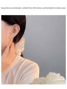 Close-up of 925 sterling silver natural pearl studs and minimalist gold ear cuffs on a model