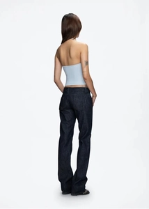 Detail view of the back showing slim fit navy blue denim jeans and a light blue halter top