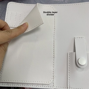 Close-up of double-layer divider and button pocket inside white faux leather nail tool bag