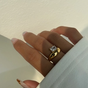 Detailed view of 18k gold plated ring with square zircon on hand in natural light