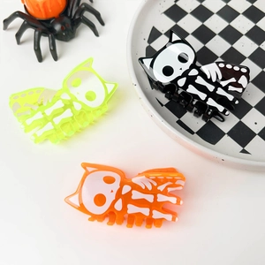 Detail view of Halloween skeleton cat hair claws in orange, black, and green acrylic