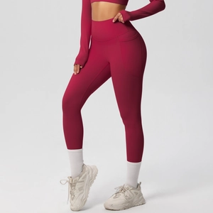 Detail of high-waisted burgundy yoga leggings with side pockets and compression fabric