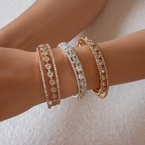 Detailed view of three layered zircon bracelets in rose gold, silver and gold finishes