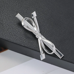 Elegant silver metal bow hair clip with high-shine finish on textured black leather