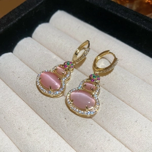 Detail of 14k gold plated gourd earrings with pink cat-eye stone and cubic zirconia