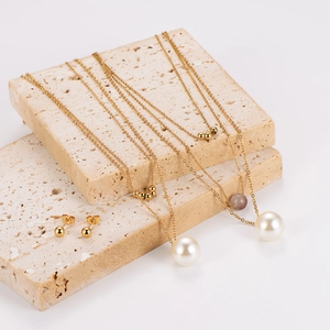 Ensemble bijoux collier double rang à perles dorées et boucles d'oreilles clous