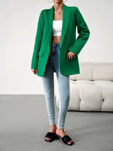 Vue détaillée d'un blazer vert pour femme avec une coupe professionnelle et épurée