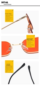 Detail of small metal sunglasses with orange lenses, reinforced hinges, and silicone nose pads