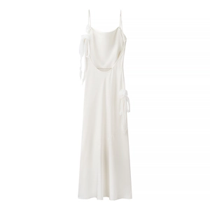 Detailed close-up of white satin dress featuring elegant bow on shoulder and ruched neckline