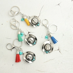 Detailed view of bohemian cowboy hat keychains with colorful tassels and turquoise beads