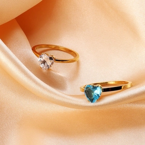 Detail of 18K gold stainless steel rings with clear and sky blue heart-shaped zircons