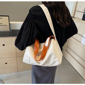 Detail of white Boston bag with vibrant orange strap and YOUBEIBAG brand label