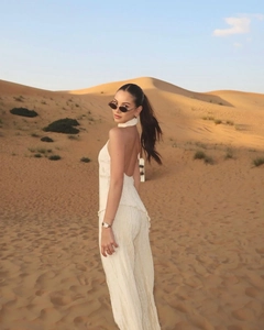 Detail of white pleated halter top and wide leg pants set with open back design
