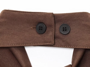 Detail of brown fabric texture with dual black round buttons and precise diagonal stitching
