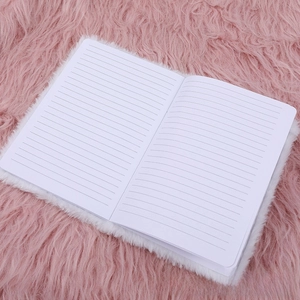 Detail of soft white plush notebook cover and lined inner pages on pink background