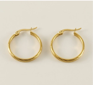 Detailed close-up of 18K gold circular hoop earrings with intricate spiral texture finish