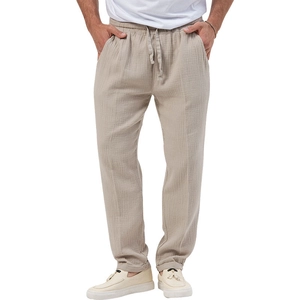Detail of men's beige linen trousers featuring an elastic drawstring waist and textured fabric