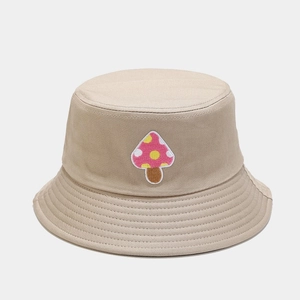 Close-up of pink mushroom embroidery detail on beige canvas bucket hat