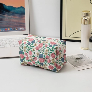 Macro detail of floral quilted cotton makeup bag with white zipper and soft texture