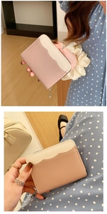Detail showing litchi texture and stylish wavy contrast stitching on women's leather wallet