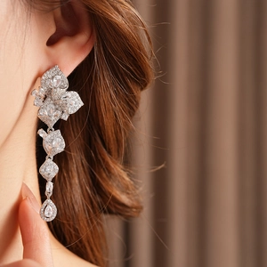 Gros plan de boucles d'oreilles fleurs en zircon avec cristaux marquise et gouttes d'eau
