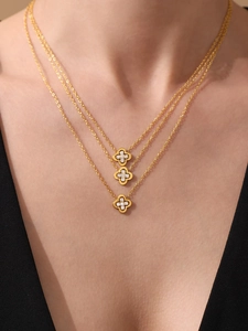 Detailed view of layered gold clover necklace with sparkling 5A zircon stones on model