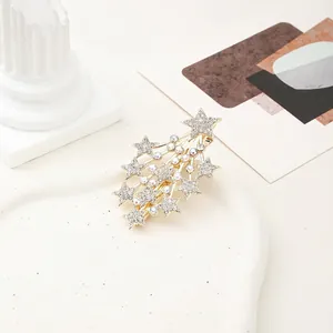 Detail of gold star hair clip with glittering rhinestones and colorful AB crystals
