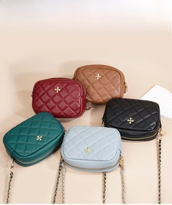 Collection of quilted crossbody bags in five colors with gold chain and floral metal emblem