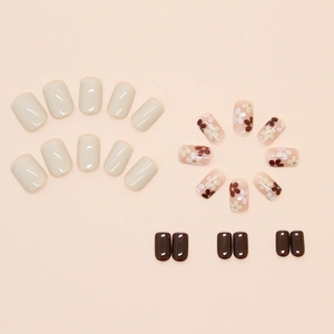 Minimalist press-on nail set featuring cream, dark brown, and floral art designs