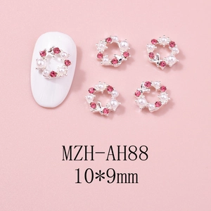 Détail de bijoux d'ongles couronne de Noël argentés avec strass roses et perles blanches
