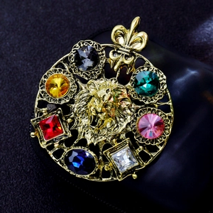 Detailed macro view of a gold lion head brooch featuring colorful gemstones and iris top