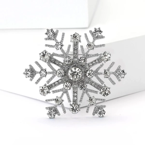 Gros plan d'une broche flocon de neige argentée avec des strass étincelants