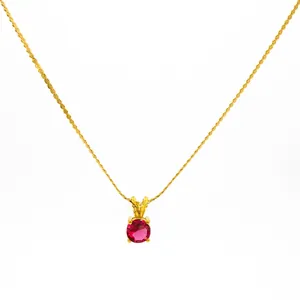 Detail of 18K gold-plated stainless steel necklace with a round red zircon gemstone pendant