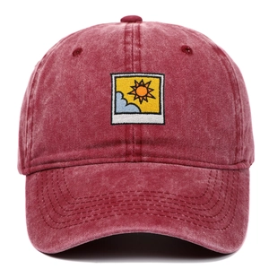 Detailed embroidery of sun and clouds on a burgundy washed cotton baseball cap