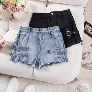Flat lay of high waisted ripped denim shorts with side buckles and frayed hem detail