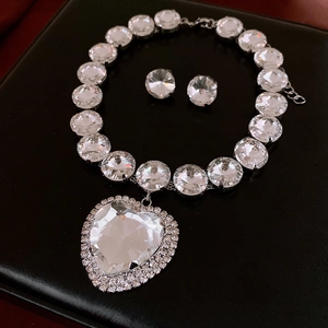 Detailed view of silver heart pendant and matching round crystal stud earrings set