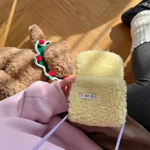 Detail of soft yellow faux lamb wool plush crossbody phone bag with label and purple strap