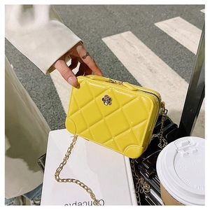 Detail of bright yellow quilted PVC jelly bag with gold chain and floral metal buckle