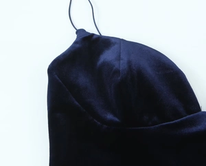 Detail shot of navy blue velvet fabric and thin shoulder strap on fashionable bodysuit