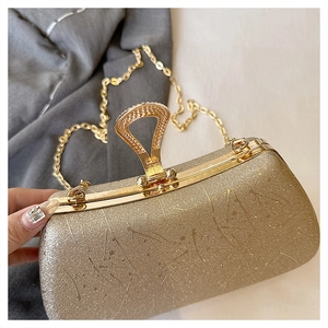 Close-up of golden glitter clutch bag with metal frame and triangle handle