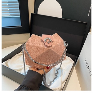 Detailed view of pink lace crossbody bag with geometric design inside black gift box