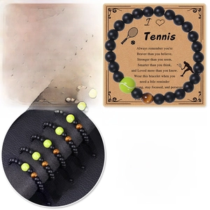 Vue macro du bracelet de tennis en oeil de tigre avec perle verte sur carte cadeau