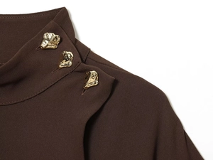 Détail du col d'une robe midi marron foncé avec trois boutons métalliques dorés dorés