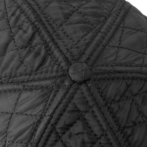 Macro view of black quilted diamond stitching and top button on the winter baseball cap