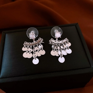 Detail of silver drop earrings with shimmering cubic zirconia and round fringe tassels