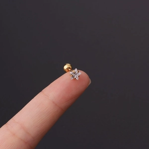 Macro view of a tiny star-shaped gold zircon stud earring with a screw back ball